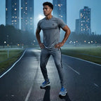Man in athletic wear standing on a road with cityscape in the background