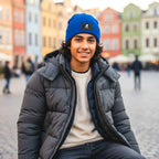 Person wearing a blue beanie and gray puffer jacket in an urban setting