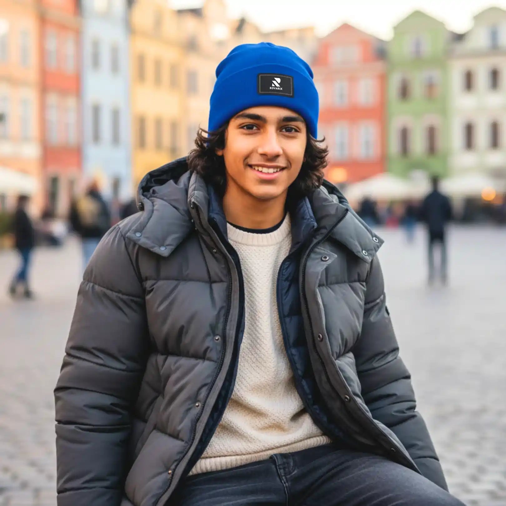 Person wearing a blue beanie and gray puffer jacket in an urban setting