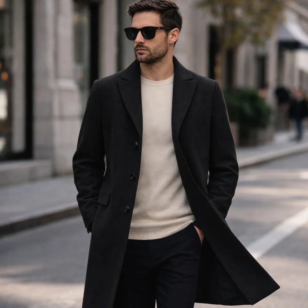 Man wearing Rovarix black wool-blend overcoat with cream sweater and sunglasses walking