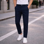 Man wearing Rovarix navy blue straight-fit chino pants with white t-shirt and sneakers walking 