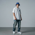 Young man wearing Rovarix blue tropical palm print bucket hat with white tee and streetwear style