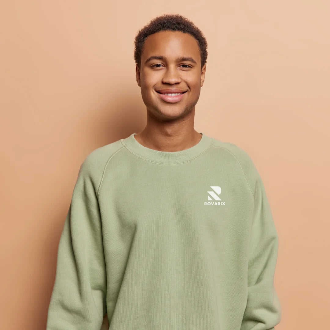 Person wearing a green sweatshirt with a logo on a beige background