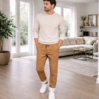 Man wearing Rovarix tan fleece-lined loungewear sweatpants with cream sweater standing