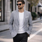 Man wearing Rovarix light gray slim-fit blazer with white crew-neck shirt and sunglasses walking