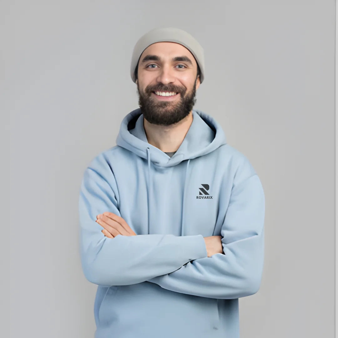 Man wearing a light blue hoodie with a logo on a gray background
