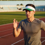 Smiling female athlete wearing the Rovarix emerald green and white performance visor outdoors.