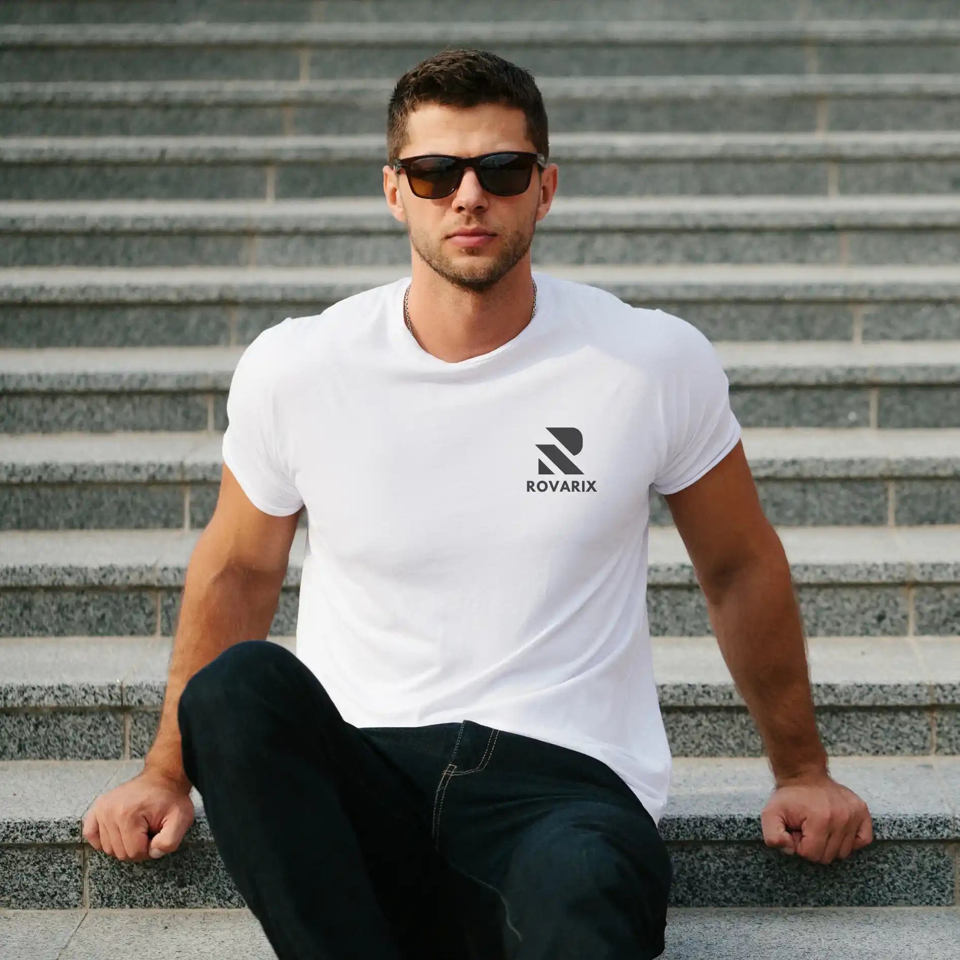 Man wearing a white t-shirt with a logo sitting on steps
