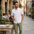 Man wearing Rovarix white Oxford short sleeve button-down shirt with olive green chinos holding iced