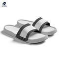 Rovarix white slide sandals with black geometric pattern straps and cushioned massage footbed