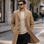 Man wearing Rovarix camel wool-blend overcoat with cream sweater and sunglasses walking